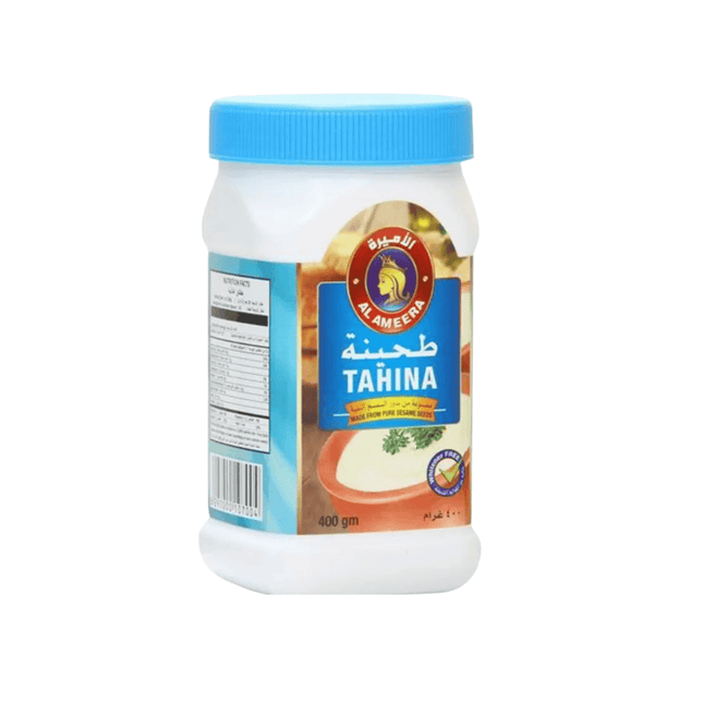 Jar of tahina with a blue lid on a white background