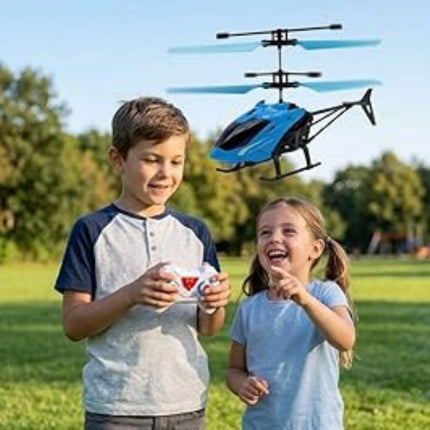 Two children playing with a blue remote control helicopter in a park.