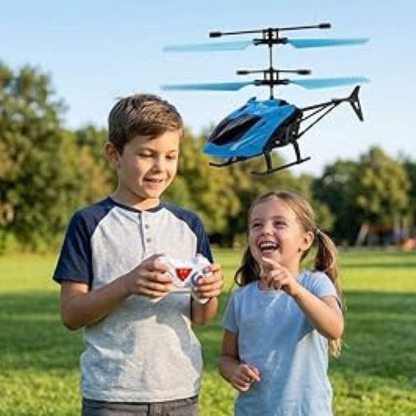 Two children playing with a blue remote control helicopter in a park.