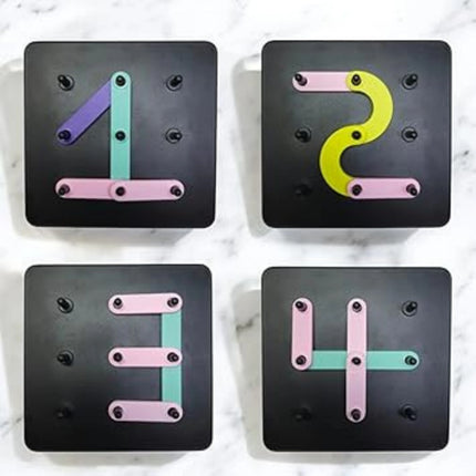 Four black square tiles with colorful numbers on a marble surface