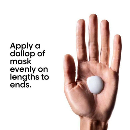 Hand holding a dollop of white cream with text on a white background