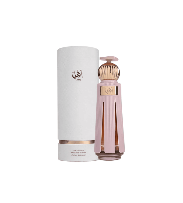 Perfume bottle with gold cap and pink body next to a cylindrical container on a white background