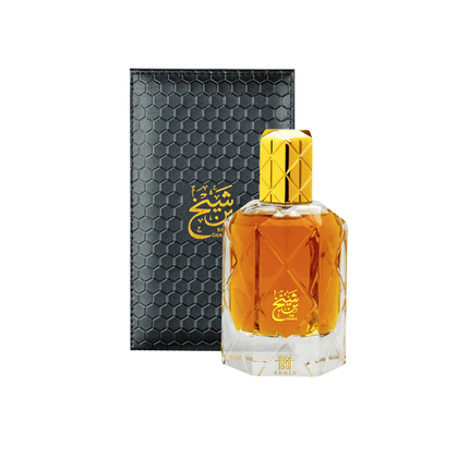 Perfume bottle with gold cap and black hexagonal packaging on a white background