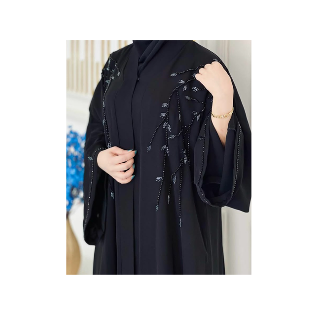 Black abaya with intricate designs on a white background