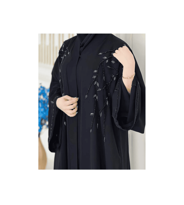 Black abaya with intricate designs on a white background
