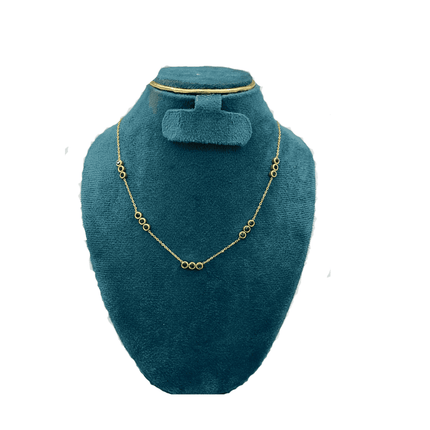 Gold necklace on a teal velvet stand with a matching hair clip.