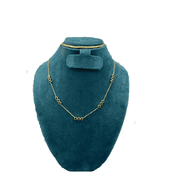 Gold necklace on a teal velvet stand with a matching hair clip.
