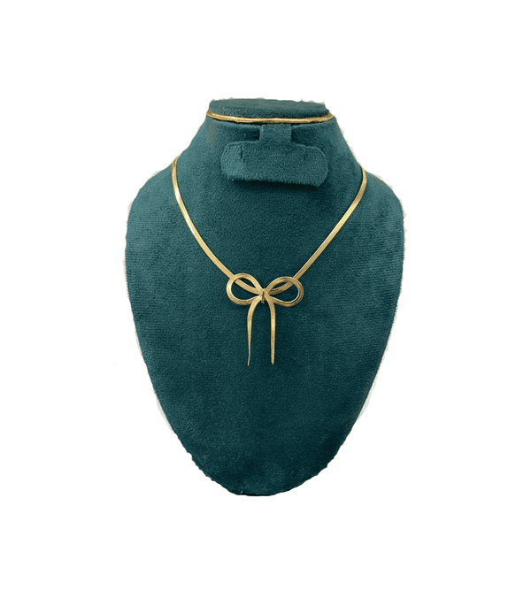 Gold necklace on a green mannequin bust with a white background