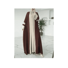 Person wearing a brown and beige abaya in a modern interior setting