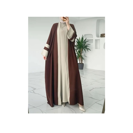 Person wearing a brown and beige abaya in a modern interior setting