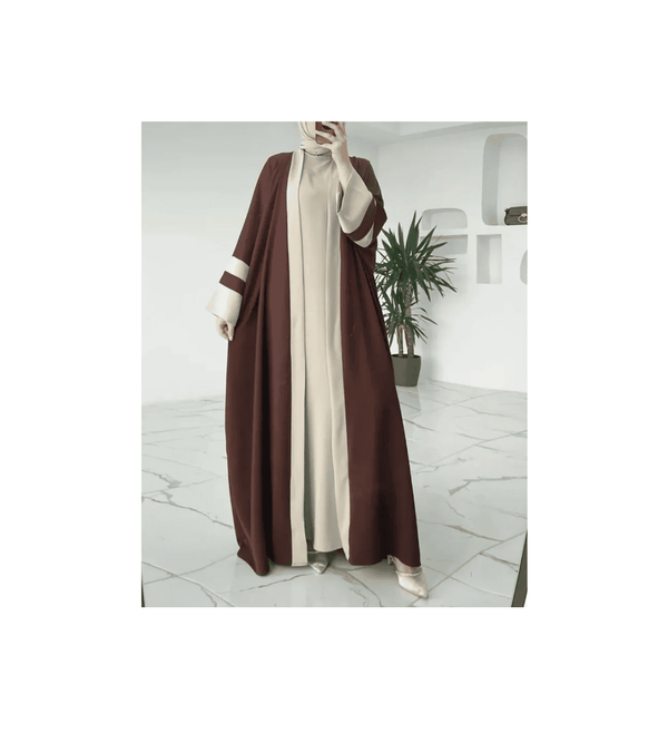 Person wearing a brown and beige abaya in a modern interior setting