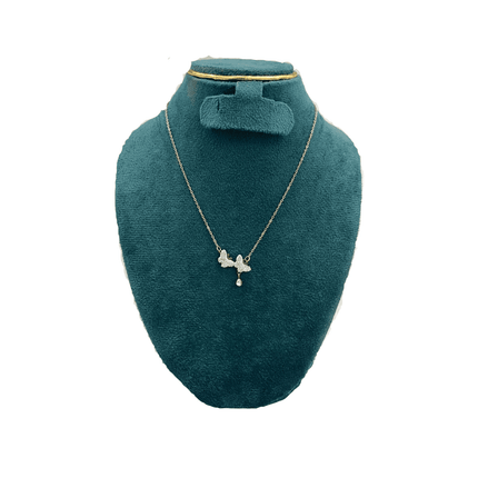 Gold necklace with a pendant on a green velvet bust against a white background