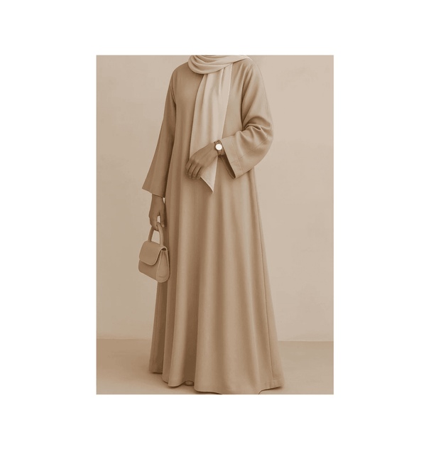 Person wearing a long beige dress with a matching hijab against a neutral background