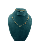 Gold necklace with clover pendants on a green velvet stand against a white background