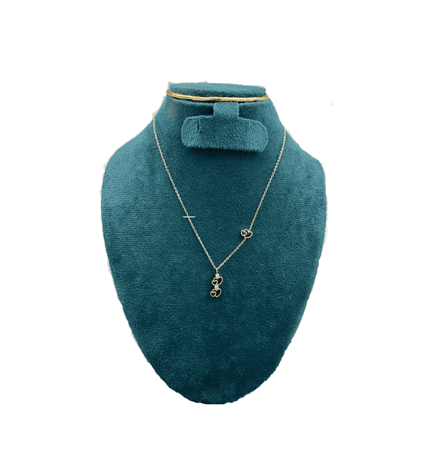 Gold necklace on a teal mannequin bust with a white background