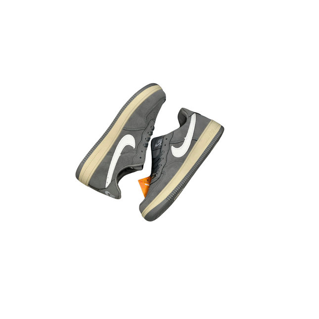 Gray sneakers with a white swoosh logo on a white background