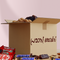 Open cardboard box with chocolate bars and dates on a light pink background