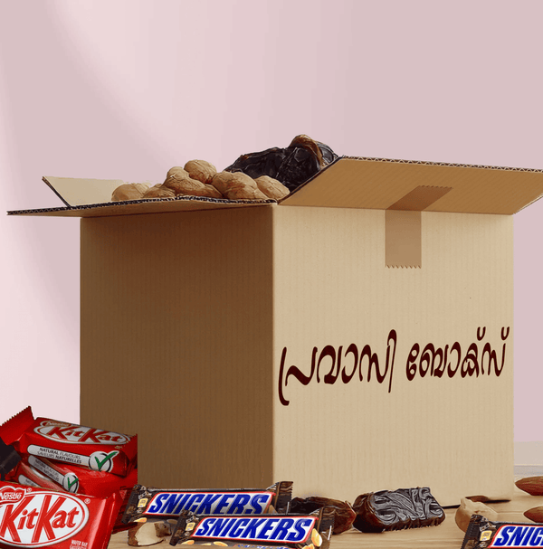 Open cardboard box with chocolate bars and dates on a light pink background