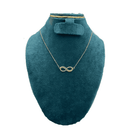 Gold infinity necklace on a teal mannequin bust with a white background