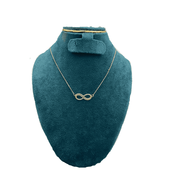 Gold infinity necklace on a teal mannequin bust with a white background