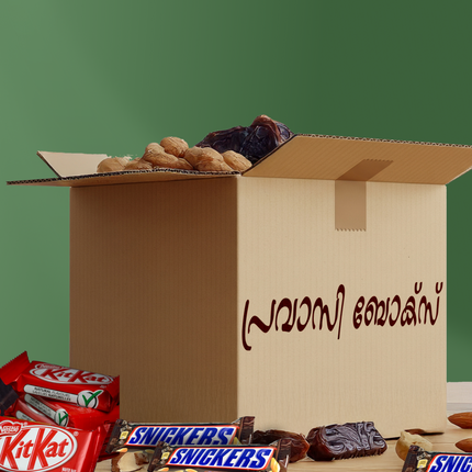 Open cardboard box with snacks and candy bars on a green background