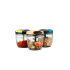Three glass containers with colorful lids, each filled with different food items on a white background.