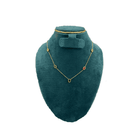 Teal velvet jewelry display with gold necklace and earrings on a white background