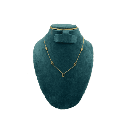 Gold necklace on a teal mannequin bust with a white background