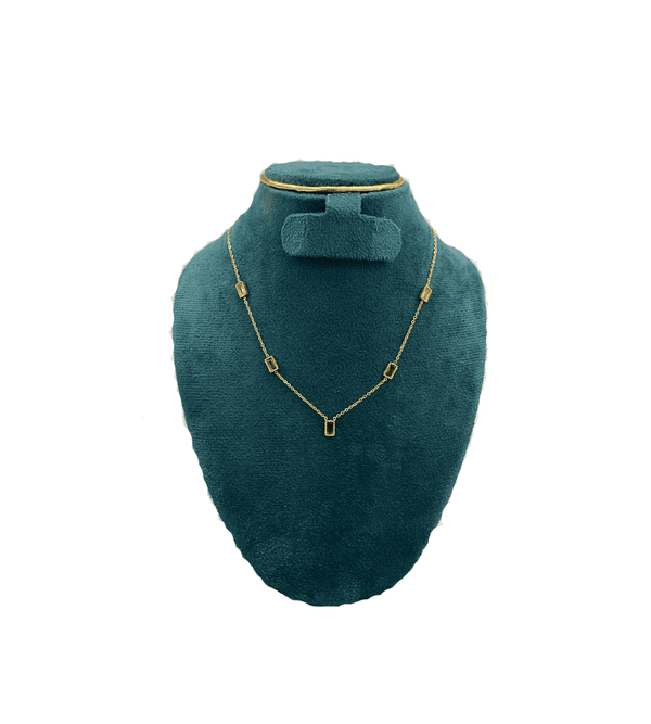 Gold necklace on a teal mannequin bust with a white background