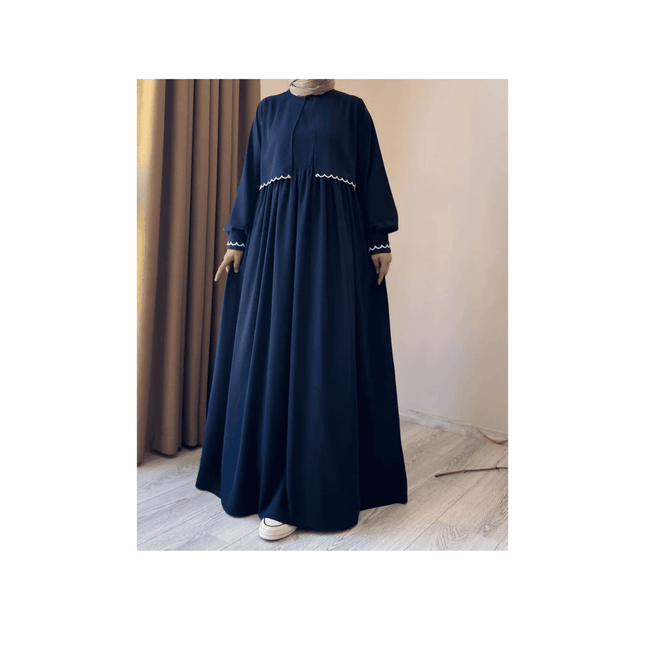 Navy blue dress with white embroidery on a neutral background