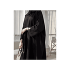 Person wearing a black outfit with a blurred background