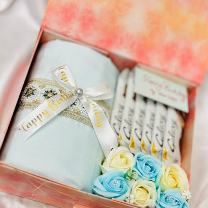 Gift set with a candle, soap flowers, and a card in a decorative box.
