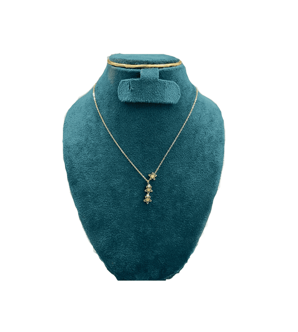 Gold necklace with star pendant on a teal mannequin bust against a white background