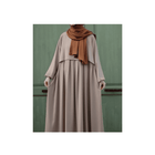 Long beige dress with a brown hijab against a green background