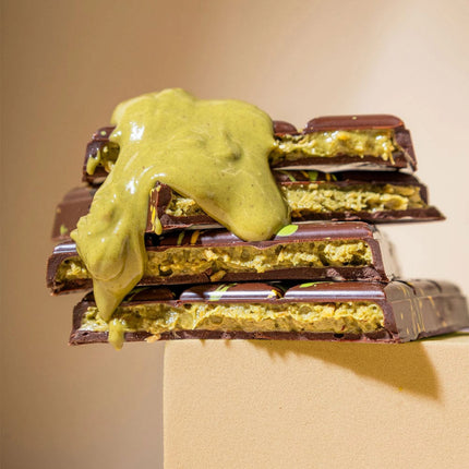 Stack of chocolate bars with green filling on a beige background