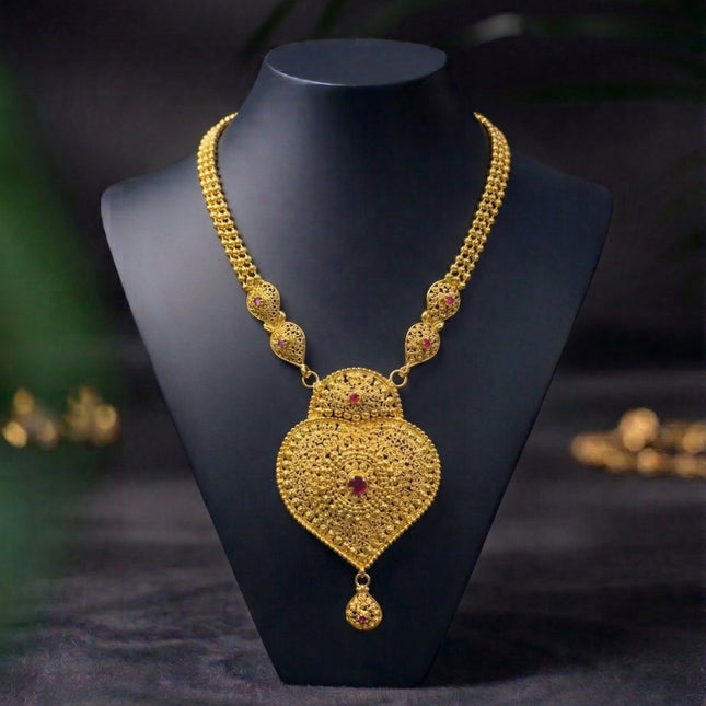 Gold necklace on a black mannequin against a dark background