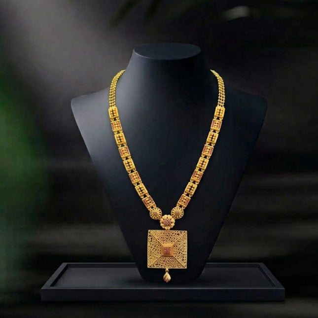 Gold necklace on a black mannequin bust with a dark background
