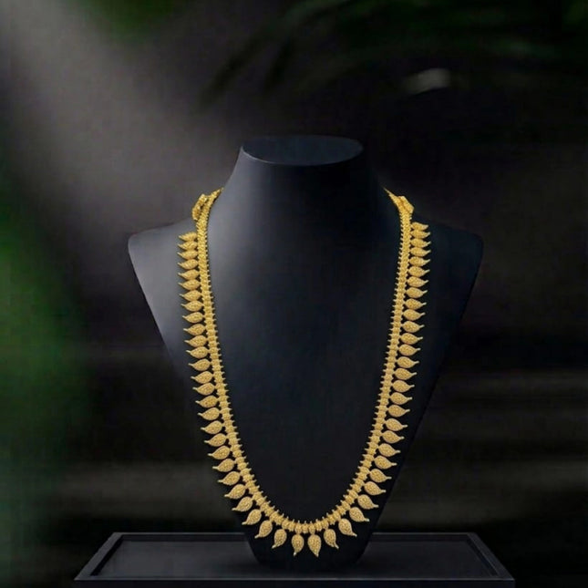 Gold necklace on a black mannequin bust with a dark background