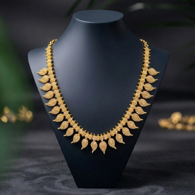Gold necklace on a black mannequin bust with a dark background