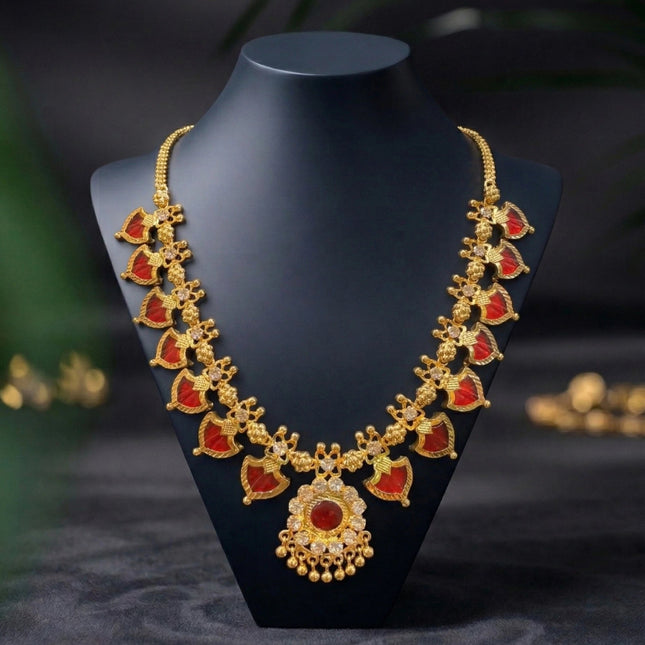 Gold necklace with red stones on a black mannequin bust