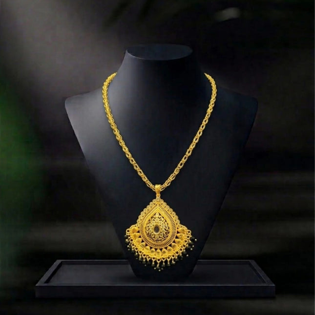Gold necklace on a black mannequin against a dark background