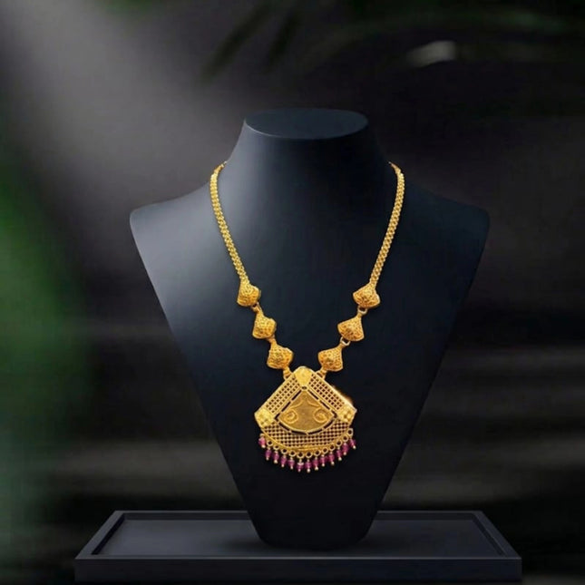 Gold necklace on a black mannequin bust with a dark background