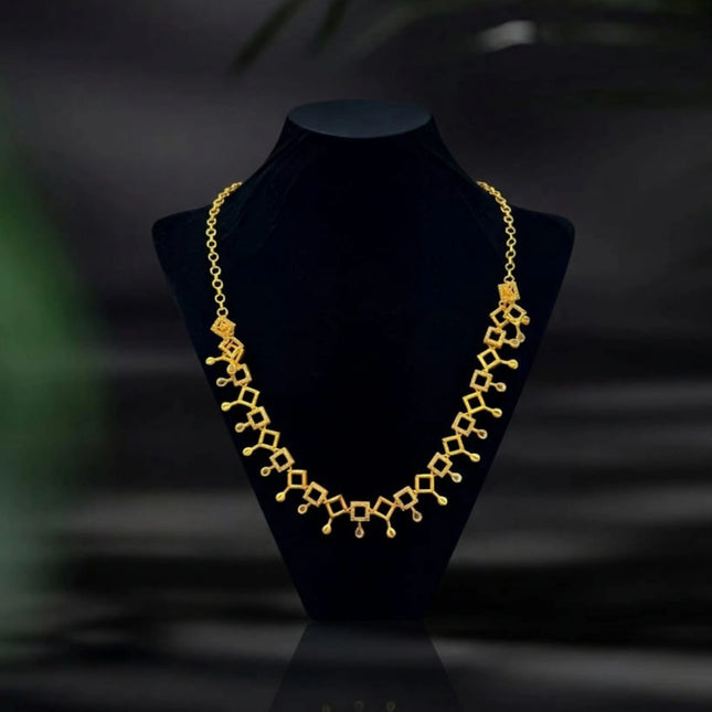 Gold necklace on a black mannequin bust with a dark background