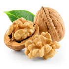 Three walnuts with a green leaf on a white background