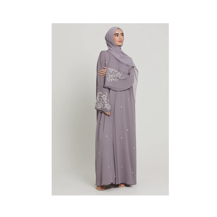 Woman wearing a gray outfit with a matching hijab on a white background