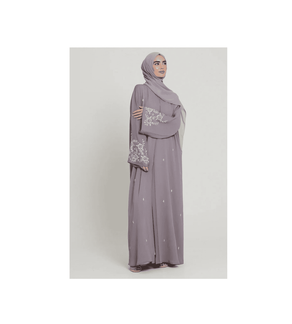 Woman wearing a gray outfit with a matching hijab on a white background