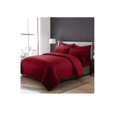 Red bedspread set on a bed in a room with a gray wall and window.