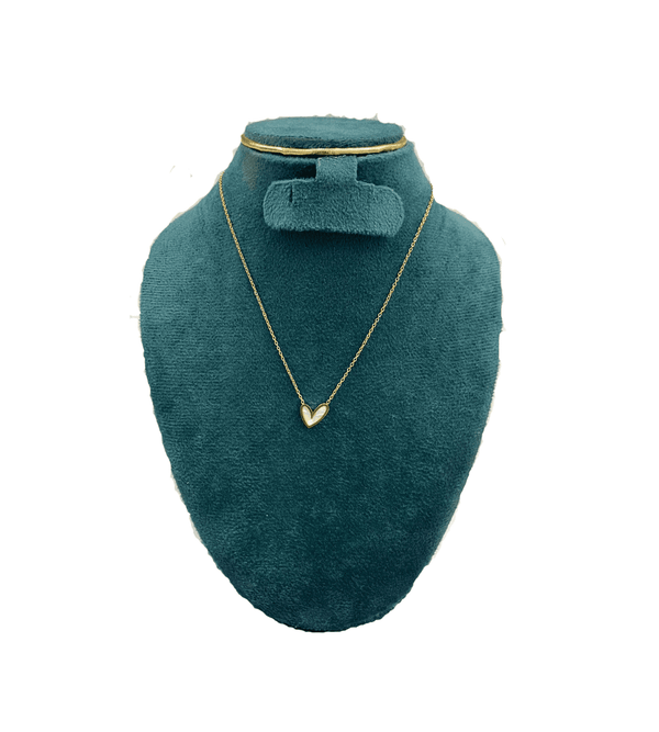Gold necklace on a green velvet mannequin bust with a white background